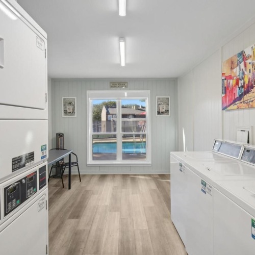 Settle into comfort at Hollyhills a room with white cabinets and a wood floor